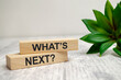 The WHAT NEXT text is written on wooden blocks and white background