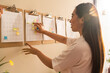 © Manu Prats/Stocksy - Asian businesswoman working with sticky notes on schedule plan
