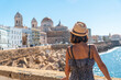 A young tourist looking at the coast of the city of Cadiz and the Cathedral. Andalusia