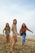 © Jovo Jovanovic/Stocksy - Three women playing at the beach together