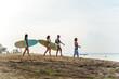 © Jovo Jovanovic/Stocksy - Women carrying surfboard at the beach