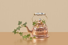 Bright Copper Kettle With Green Vine Leaves.
