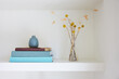 © Trinette Reed/Stocksy - Books, vase and flowers on shelf in home