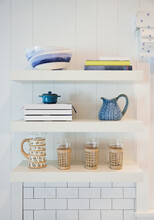 Books And Dishes On Shelf In Farmhouse Kitchen 