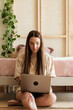 © Malquerida Studio/Stocksy - Young woman using laptop at home
