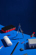 © AUDSHULE/Stocksy - Office supplies arranged on blue desk