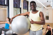 © JackF - Portrait of man pilates trainer standing with fitness ball during group training at yoga studio