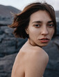 © Anastasia Mihaylova (Shpara)/Stocksy - Close up vertical photo of Woman's portrait on Lava Field