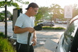 © Gabriel (Gabi) Bucataru/Stocksy - Man holding EV charging connector