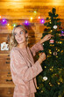 © BONNINSTUDIO/Stocksy - Blond female decorating Christmas tree