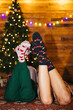 © BONNINSTUDIO/Stocksy - Girlfriends relaxing on floor near Christmas tree