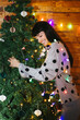 © BONNINSTUDIO/Stocksy - Happy brunette hugging Christmas tree