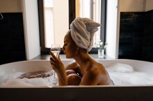 Meditative Female With Champagne Chilling In Bathtub
