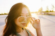 © VICTOR TORRES/Stocksy - Charming woman in sunglasses standing on street