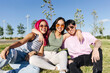 © VICTOR TORRES/Stocksy - Cheerful friends sitting on grass in park