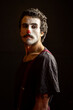 © Albert Martinez/Stocksy - Serious male clown with makeup gazing at camera