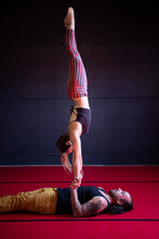 Fit Couple Performing Acrobatic Trick In Studio