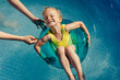 © Sergey Narevskih/Stocksy - Girl chilling on tube near mother in pool