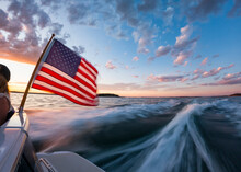 American Flag Off Stern Of Boat With Wake At Sunset Coast Of Maine