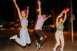 © VICTOR TORRES/Stocksy - Happy friends having fun at night jumping and raising arms