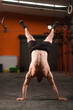 © Ibai Acevedo/Stocksy - Anonymous athlete doing handstand at the gym