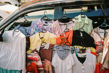 Lots Of Clothes Hanging On The Car For Sale At The Local Market