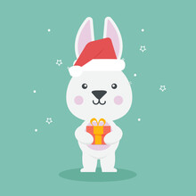 Cute White Bunny Wearing Red Stocking Cap And Holding A Gift. Rabbit In Cartoon Style.Year Of The Rabbit. Winter Holidays.Vector Illustration