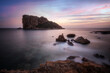 © Aytug Bayer - Long exposure photography of an island and rocks, with light the rocks glowing and with clouds and beautiful colored sunset painted sky
