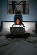 © David Prado/Stocksy - Smiling african woman using laptop in bed at night