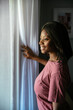 © David Prado/Stocksy - Black woman looking out window