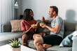© David Prado/Stocksy - Content diverse couple eating poke bowls at home