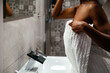 © David Prado/Stocksy - anonymous Black woman in towels standing in bathroom