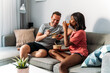 © David Prado/Stocksy - Content diverse couple eating poke bowls at home