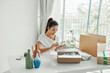 © Marc Tran/Stocksy - A woman checks online orders in preparation for delivery