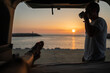 © Lupe Rodríguez/Stocksy - young couple in camper van watching the sunset at sea