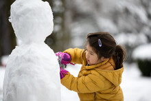 Little Kid Building A Snowman