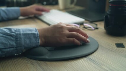 Wall Mural - close-up of hand of woman or female freelancer using computer mouse and clicking, while surfing the 