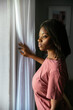 © David Prado/Stocksy - Black woman looking out window