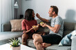 © David Prado/Stocksy - Content diverse couple eating poke bowls at home