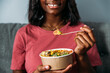 © David Prado/Stocksy - Faceless black woman eating poke bowl