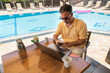 © Hernandez & Sorokina/Stocksy - Man Using Smartphone In Resort Terrace
