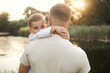 © Iuliia Versta/Stocksy - dad holds his son in his arms in nature