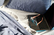 © Rowena Naylor/Stocksy - Unmade bed with laptop and reading glasses