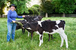 © Rowena Naylor/Stocksy - Farmer with young dairy calves