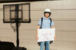 © ByLorena/Stocksy - Teenager with banner first day of school