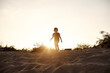 © Iuliia Versta/Stocksy - silhouette of a little boy running in a sandy land