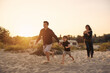 © Iuliia Versta/Stocksy - happy family runs on the sandy beach