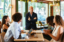 Diverse Employees Listening To Boss In Restaurant