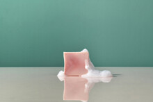 Piece Of Pink Soap And Foam On A Reflective Surface