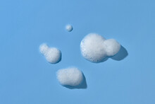 White Soap Bubbles Foam On Blue Background.